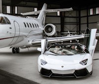 a white lamborghini sports car parked next to a private jet